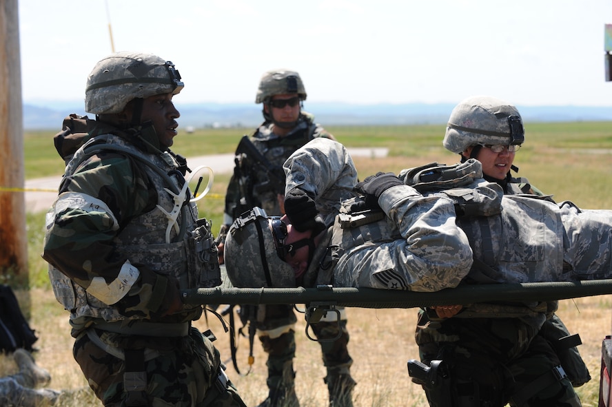 Defenders from the 28th Security Forces Squadron carry a fellow Airman with a simulated injury to a medical treatment facility during the Phase II portion of an operational readiness exercise at Ellsworth Air Force Base, S.D., July 11, 2013. Airmen are trained on self-aid and buddy care annually, and sometimes more frequently, to ensure they stay up to date on the most current and effective life-saving procedures that could become necessary during real world contingencies. (U.S. Air Force photo by Airman 1st Class Rebecca Imwalle/Released)

