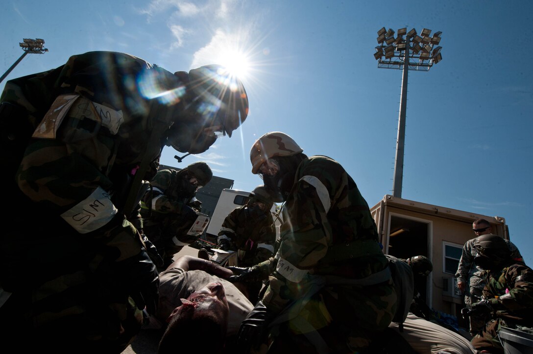 Airmen assigned to the 28th Aircraft Maintenance Squadron treat simulated patients with self-aid and buddy care on the flightline during the Phase II portion of an operational readiness exercise at Ellsworth Air Force Base, S.D., July 11, 2013. The intent of Phase II is to evaluate the wing’s ability to meet wartime and contingency tasks of employing forces, sustaining forces and maintaining the ability to survive and operate in a deployed location. (U.S. Air Force photo by Airman 1st Class Zachary Hada/Released)