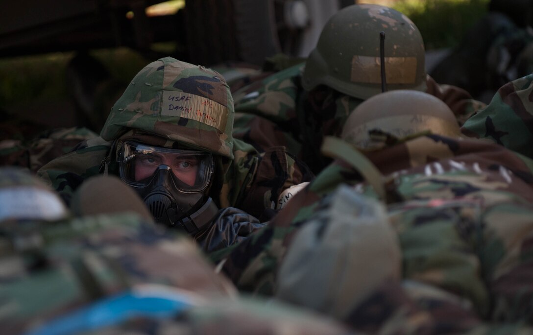 Airman 1st Class Daniel Sorters, 28th Aircraft Maintenance Squadron load crew member, takes cover with other Airmen during Alarm Red on the flightline during the Phase II portion of an operational readiness exercise at Ellsworth Air Force Base, S.D., July 11, 2013. Alarm Red signifies to the base that an attack is imminent or in progress and that all Airmen should seek cover immediately. (U.S. Air Force photo by Airman 1st Class Zachary Hada/Released)