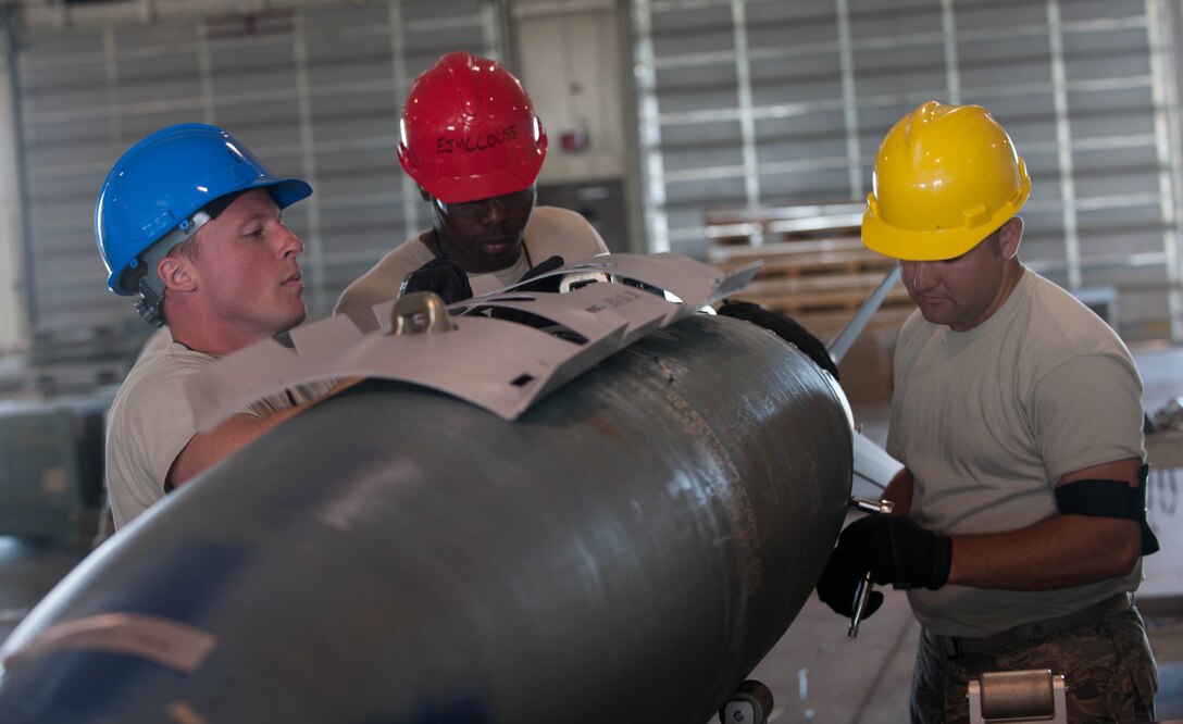 Conventional maintenance crew members assigned to the 28th Munitions Squadron assemble inert guided bomb units during the Phase II portion of an operational readiness exercise at Ellsworth Air Force Base, S.D., July 10, 2013. The 28th MUNS Airmen are responsible for 1,707 munitions line items, 86 facilities and a 647-acre munitions storage area to support B-1 bomber operations. (U.S. Air Force photo by Airman 1st Class Zachary Hada/Released)