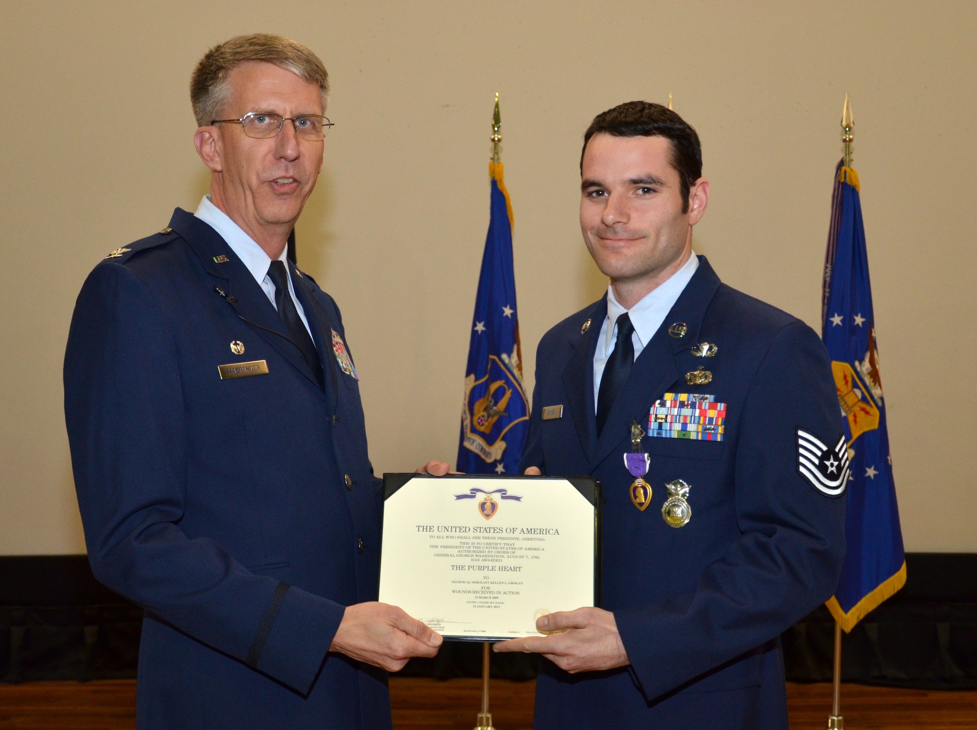 Col. Jeffrey Macrander, 920th Rescue Wing commander, presents Tech. Sgt. Kellen Grogan, 920th Security Forces Squadron squad trainer, the certificate to accompany his Purple Heart medal at a commander’s call March 3, 2013 at Patrick Air Force Base, Fla. Grogan was awarded the Purple Heart for wounds received in action March 19, 2005. (U.S. Air Force photo/Tech. Sgt. Anna-Marie Wyant)