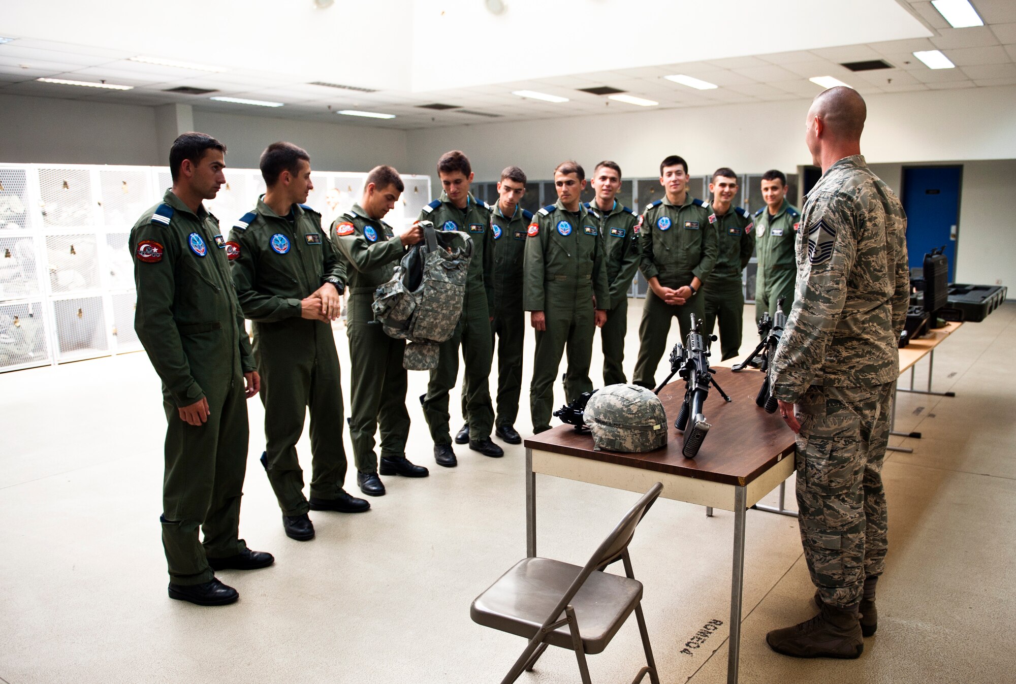 Turkish air force cadets feel the weight of individual protective equipment during a briefing from Senior Master Sgt. Todd Rosenzwieg, 39th Security Forces Squadron superintendant, July 15, 2013, at Incirlik Air Base, Turkey. The cadet tour provided opportunities to strengthen the solidarity between the two NATO allies. (U.S. Air Force photo by Senior Airman Daniel Phelps/Released))