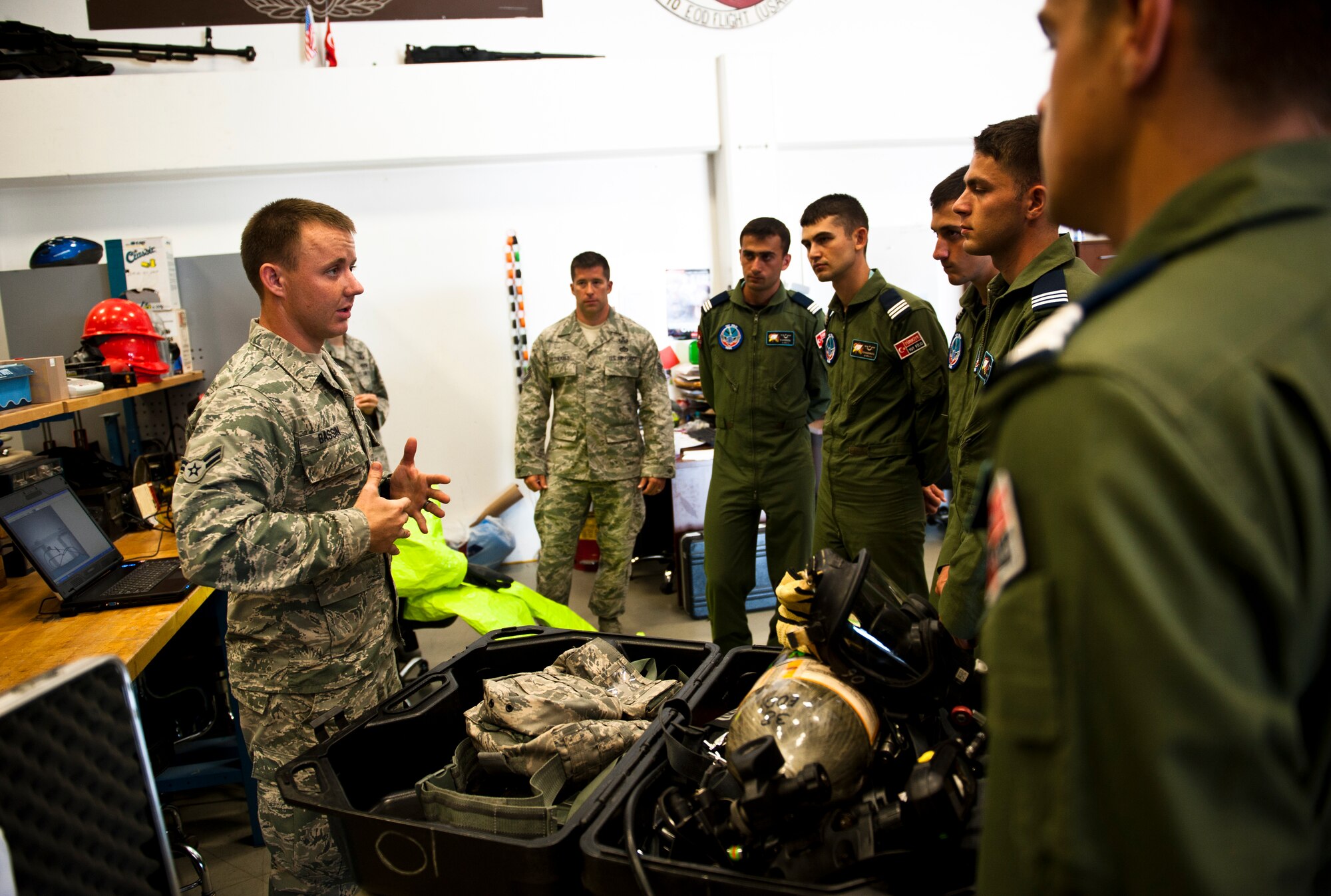 Airman 1st Class Samuel Bassin, 39th Civil Engineer Squadron explosive ordnance disposal technician, briefs Turkish air force cadets on some of the EOD tools the flight uses July 15, 2013, at Incirlik Air Base, Turkey. The cadets had the opportunity to try out some of the EOD equipment on their base tour. (U.S. Air Force photo by Senior Airman Daniel Phelps/Released)