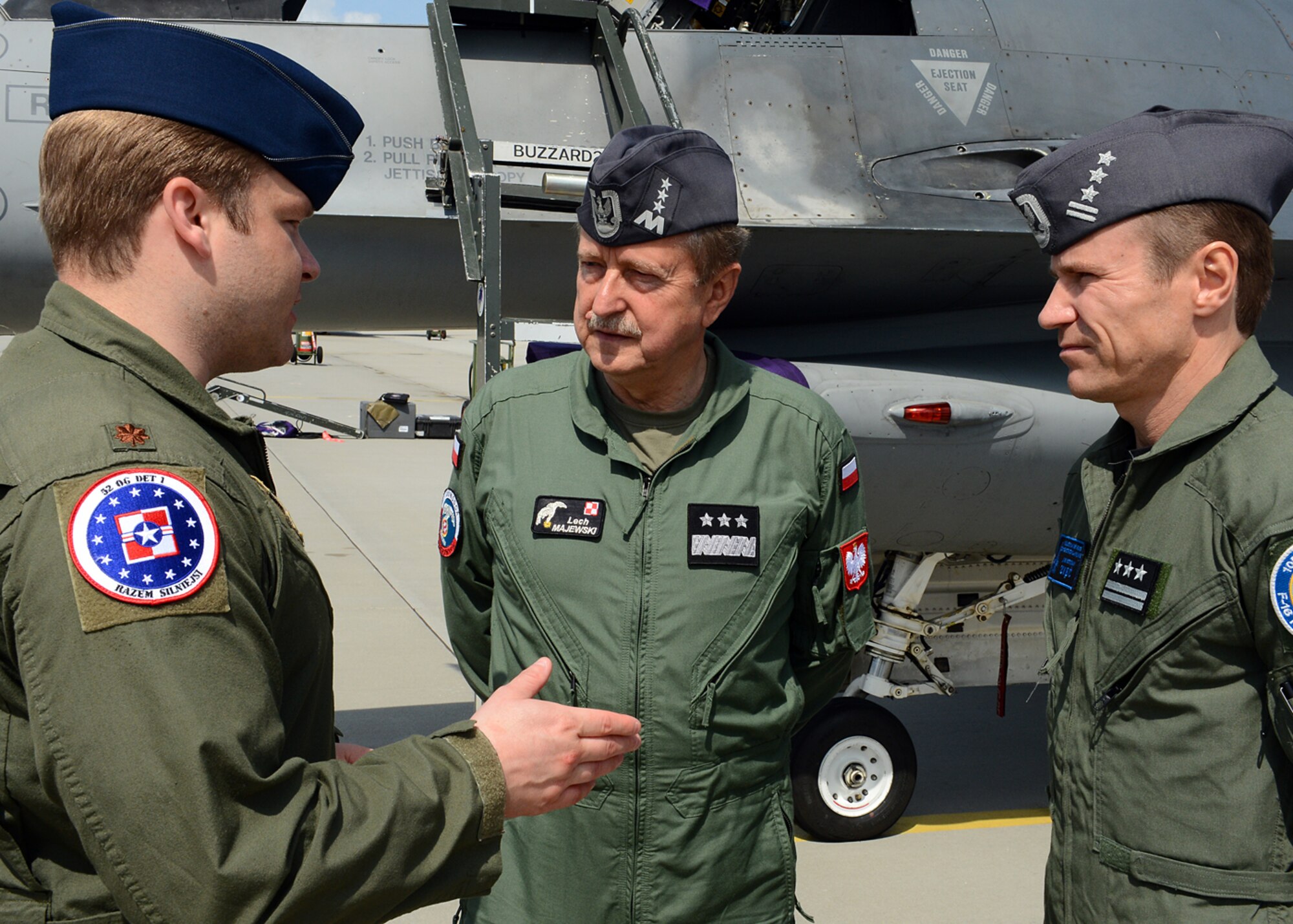 LASK AIR BASE, Poland -- U.S. Air Force Maj. Matthew Spears, commander of Detachment 1, 52nd Operations Group, talks with Polish air force commander Lt. Gen. Lech Majewski and Col. Krystian Ziec, 32nd Tactical Air Base commander, discuss future partnership-building events July 17, 2013. Spears' aviation detachment is a training hub for all inbound U.S. aircraft into Poland, and the unit has organized four aircraft rotations a year. Aviano Air Base, Italy, supplied the Airmen for this rotation — the third since the aviation detachment's creation in 2012. (U.S. Air Force photo by Staff Sgt. Daryl Knee/Released)