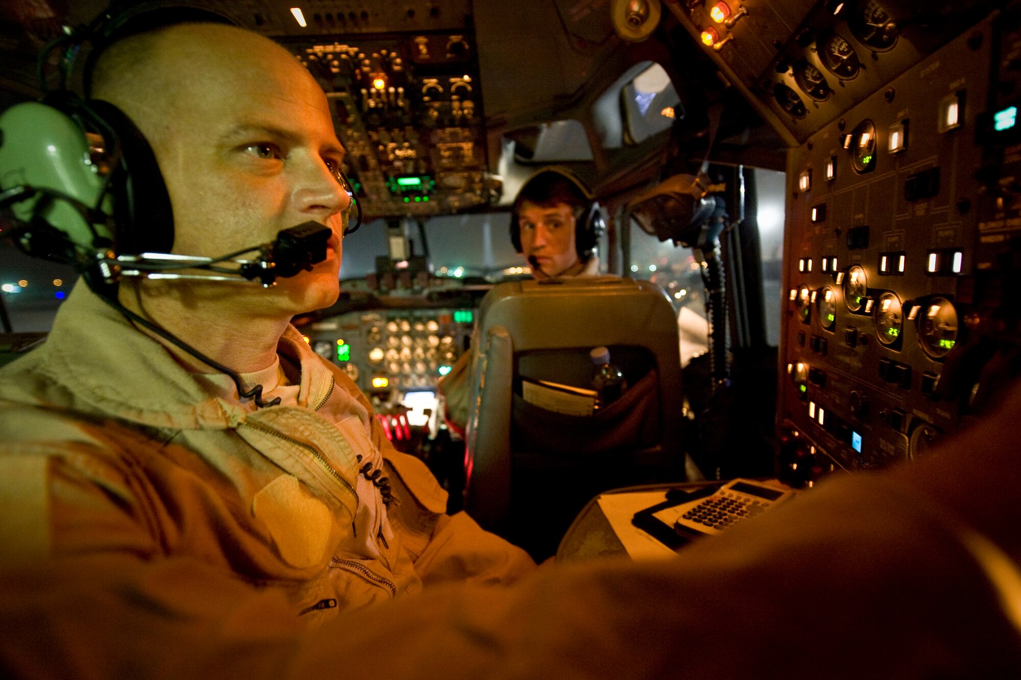 Master Sgt. Mike runs through pre-flight checks onboard an E-8C Joint Surveillance Target Attack Radar System as Capt. Jared looks on at the 379th Air Expeditionary Wing in Southwest Asia, July 11, 2013. Mike is a 7th Expeditionary Airborne Command and Control Squadron flight engineer and Jared is a 7th EACCS pilot. (U.S. Air Force photo/Senior Airman Benjamin Stratton)
