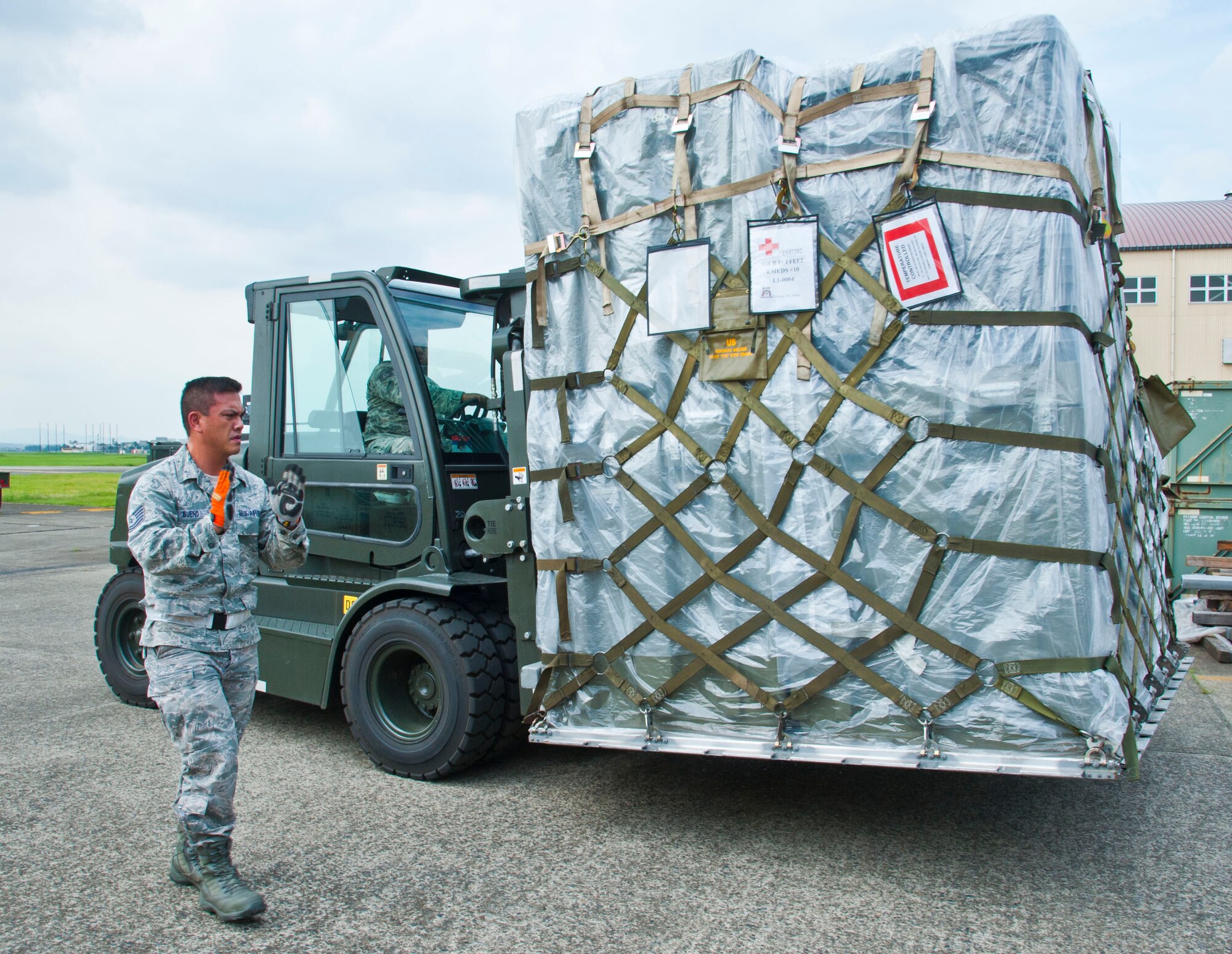 YOKOTA AIR BASE, Japan – Tech. Sgt. Christopher Bueno, the non-commissioned officer in charge of acquisition with the 374 Medical Support Squadron gives direction to Tech. Sgt. Kelvin Wilder, the NCO in charge of customer service with 374 Medical Logistics at Yokota Air Base, Japan, July 16, 2013.  The 374 Medical Group tested the wing’s capability to deploy medical assets for humanitarian missions.  (U.S. Air Force photo by Airman 1st Class Soo C. Kim)