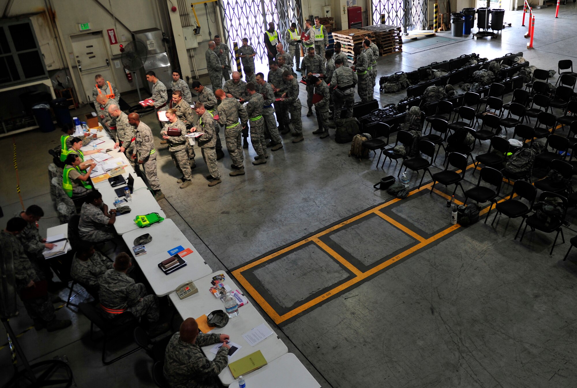 Airmen from the 374th Security Forces Squadron process through a deployment line at Yokota Air Base, Japan, July 16, 2013. The deployment line personnel check Airmen for readiness requirements. Lines are used for mass deployment purposes and allow Airmen to quickly receive administrative help from organizations such as medical, chapel and finance.  (U.S. Air Force photo by Senior Airman Cody H. Ramirez)