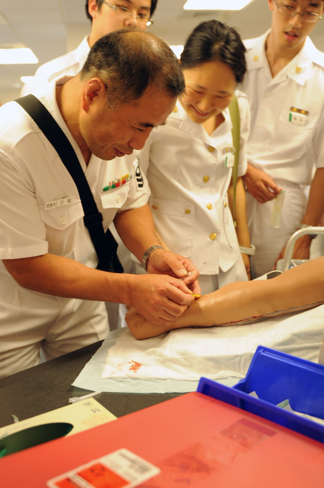 YOKOTA AIR BASE, Japan -- A member of the Japan Maritime Self-Defense Force practices placing an IV in a training mannequin arm July 11, 2013, at Yokota Air Base, Japan. A few JMSDF members and medical students from the National Defense Medical College toured the 374th Medical Group during a visit to Yokota. (U.S. Air Force photo by Senior Airman Desiree Economides)