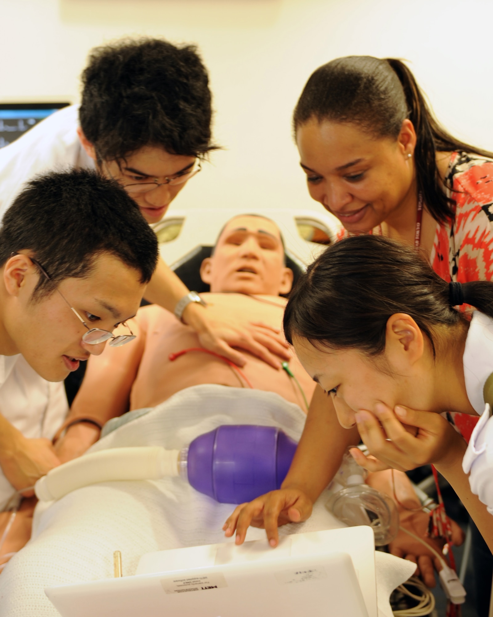YOKOTA AIR BASE, Japan -- Top right, Michelle Ball, 374th Medical Group medical simulator operator, points out information on a computer to Japanese medical students July 11, 2013, at Yokota Air Base, Japan. Third-year medical students from the National Defense Medical College learned how the 374th Medical Group trains on high-tech mannequins for training. (U.S. Air Force photo by Senior Airman Desiree Economides)