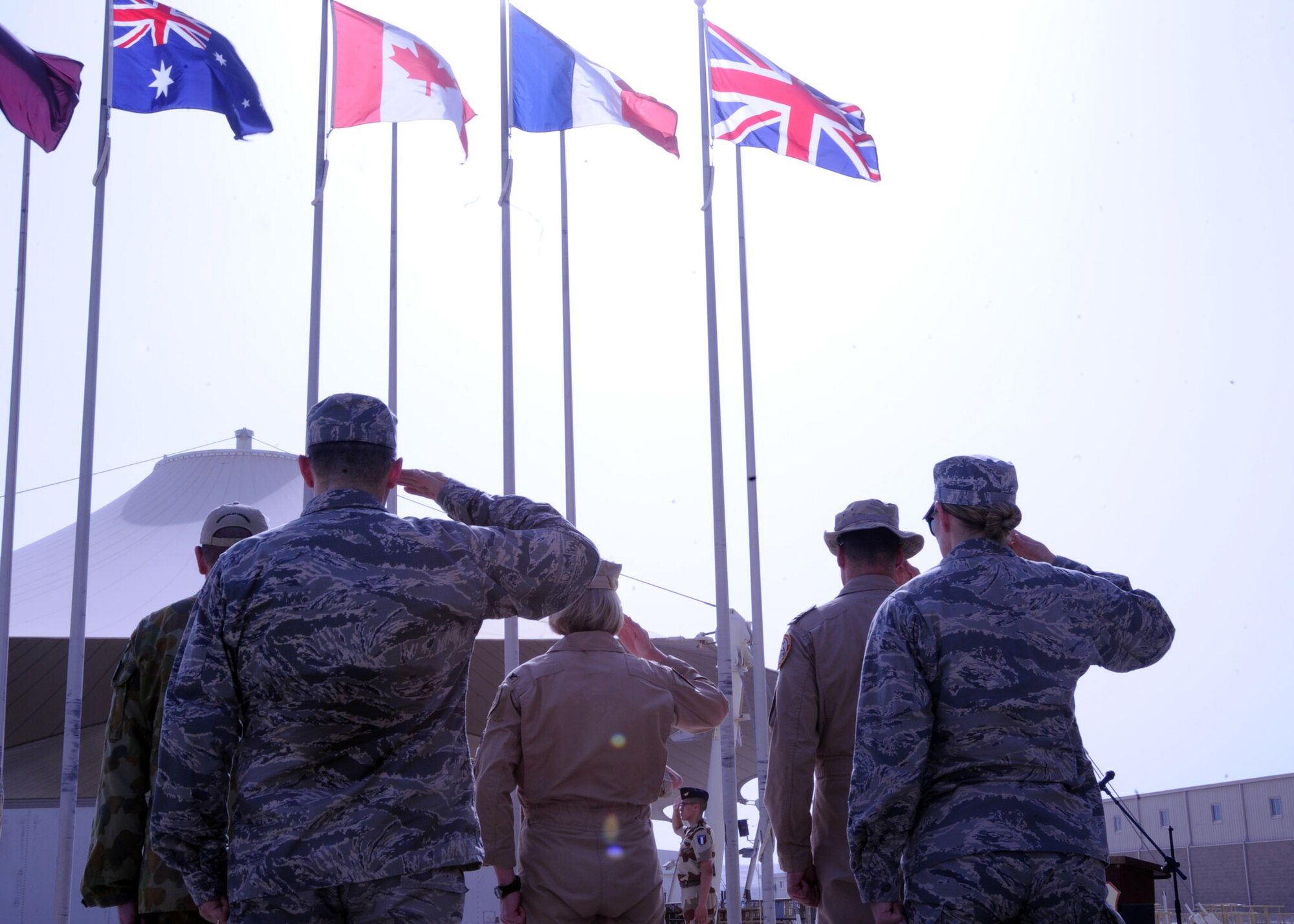 Coalition forces salute the French flag during a Bastille Day ceremony at the 379th Air Expeditionary Wing in Southwest Asia, July 14, 2013. The taking of Bastille in 1789 signaled the beginning of the French Revolution.  (U.S. Air Force photo/Senior Airman Bahja J. Jones) 