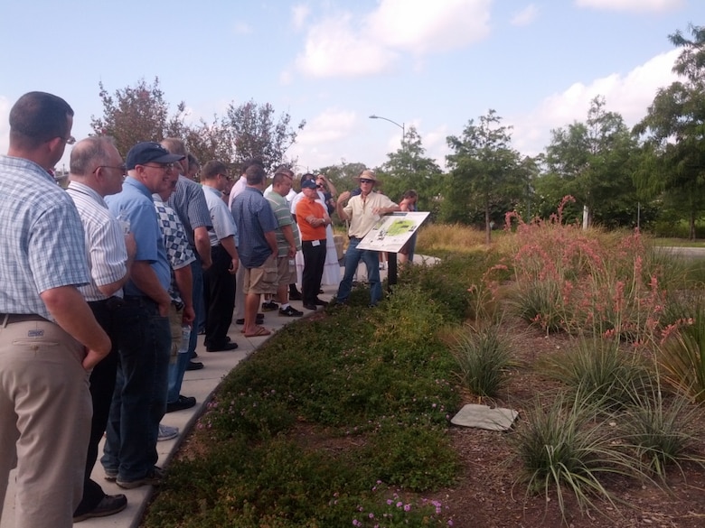 A group of students participate look at a biorentention area, or rain garden, during low impact development training. 