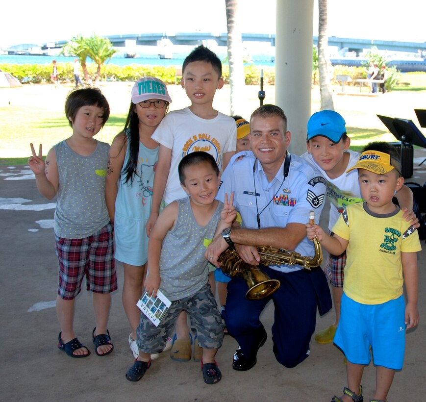 PEARL HARBOR, Hawaii -- Staff Sergeant Miles Hudlow, Band of the Pacific-Hawaii saxaphonist, poses with fans from China after a performance by "Papana", the jazz ensemble from the USAF Band of the Pacific-Hawaii, Pearl Harbor, Hawaii, Jul. 17, 2013. The group performed for a Pearl Harbor survivor and to many other visitors, building stronger community and international relations through music. The Pearl Harbor Memorial receives more than 4,000 visitors a day and is the most popular attraction on Oahu. (US Air Force Photo by SSgt Courtney Clifford/released) 
