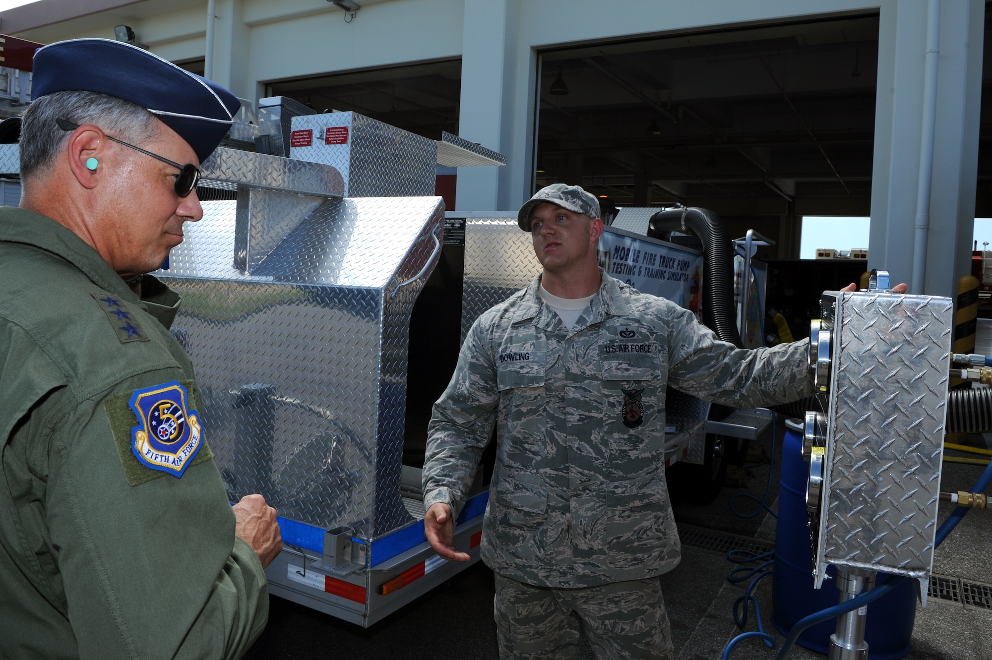 U.S. Air Force Lt. Gen. Sam Angelella, U.S. Forces Japan and 5th Air Force commander, receives a briefing on the Draft Commander Mobile Fire Truck Pump Testing and Training Simulator on Kadena Air Base, Japan, July 10, 2013. The machine tests fire pumps and ensures the pumps work properly during an emergency. Before the draft commander, fire trucks used between 400,000 and 2 million gallons of water for pump testing and training purposes, and now uses approximately 3,000 gallons of water for a fleet and training. (U.S. Air Force photo by Airman 1st Class Hailey R. Davis/Released)