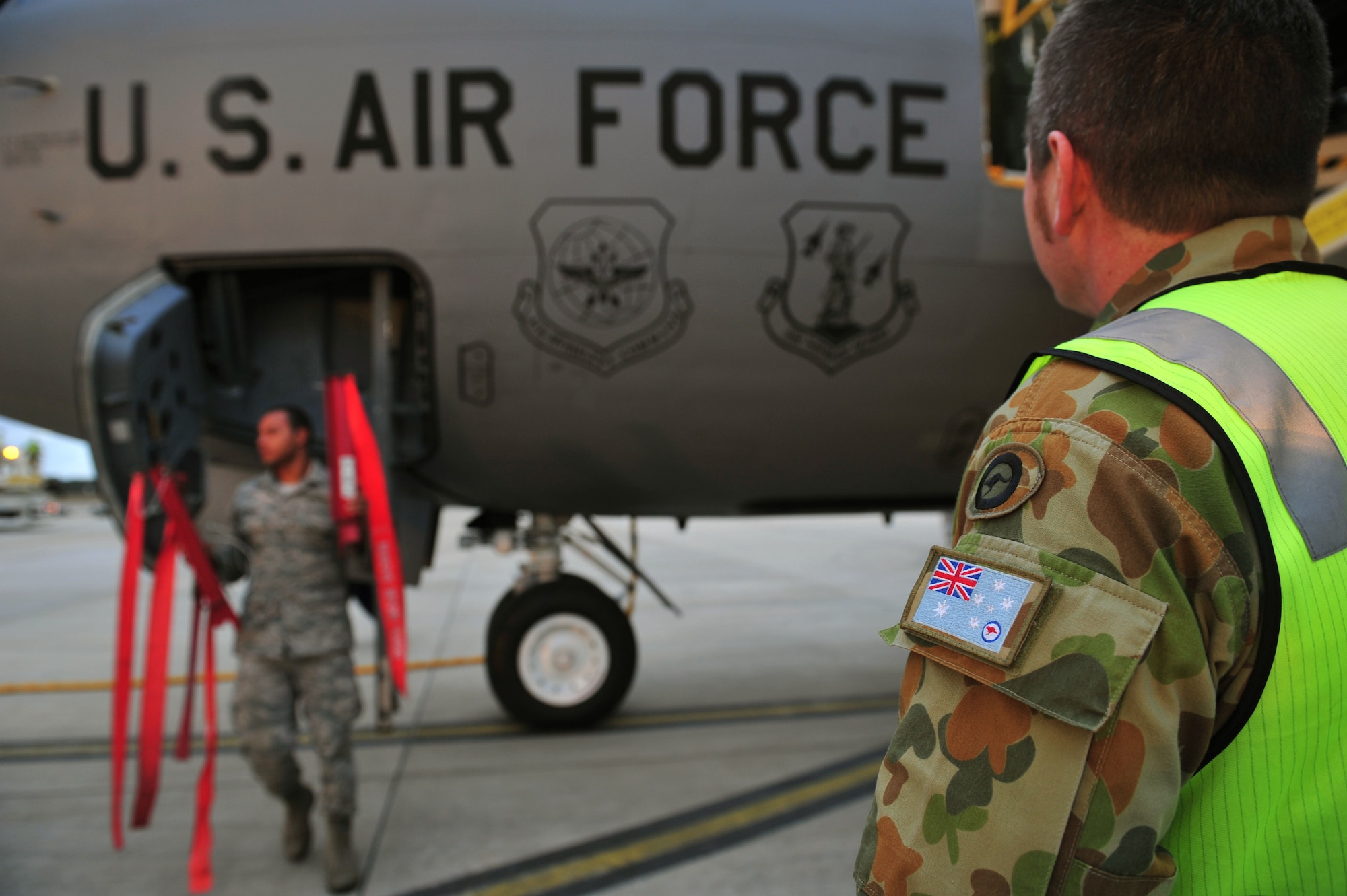 Royal Australian Air Force Sergeant Christopher Sharp, 1st Airfield Operations Support Squadron, looks on as U.S. Air Force Airmen start to deplane a KC-135 Stratotanker, RAAF Base Amberley, Australia, July 15, 2013. Two KC-135s arrived to support Talisman Saber 2013, an exercise that provides realistic, relevant training necessary to maintain regional security, peace and stability. (U.S. Air Force photo by Staff Sgt. Rachelle Coleman/Released)