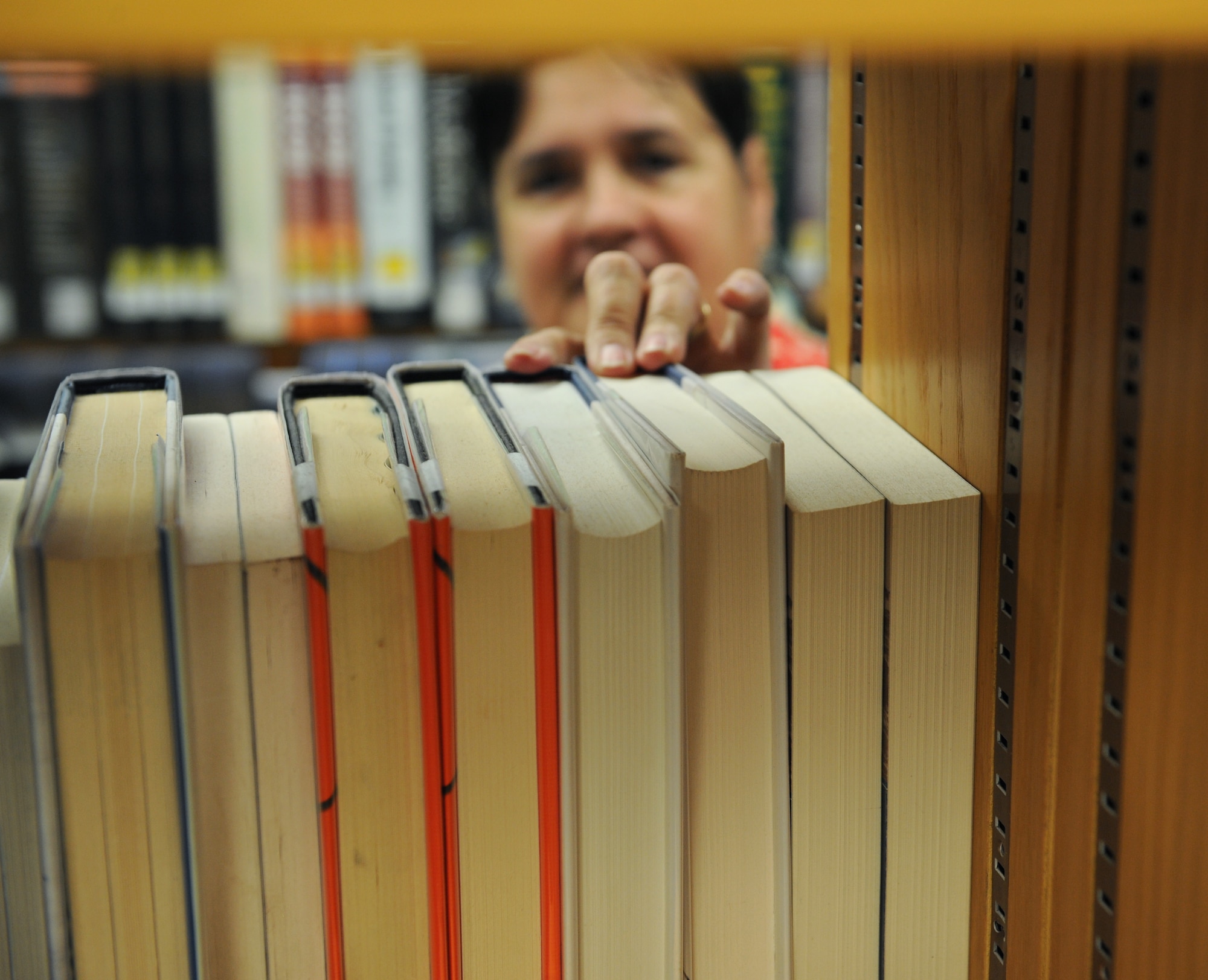 Fran Morris, 2nd Force Support Squadron library director, reaches for a book at the library on Barksdale Air Force Base, La., July 17, 2013. The library's book selection ranges from novels to college test study guides for Barksdale Airmen and their families. (U.S. Air Force photo/Airman 1st Class Benjamin Gonsier)

