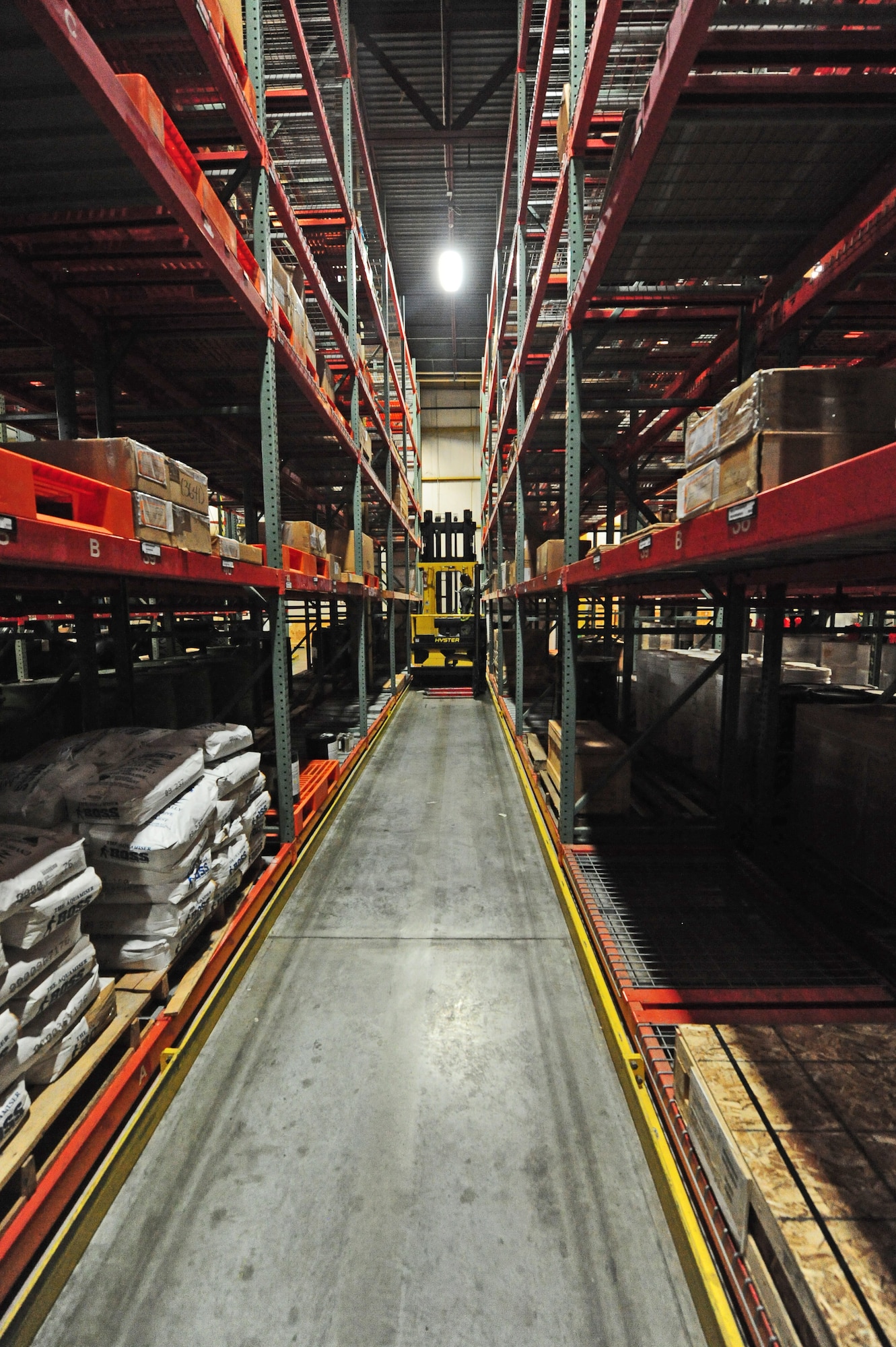 Airman 1st Class Terrell Grant, 509th Logistics Readiness Squadron central storage journeyman, drives a hyster up an aisle to pull a piece of equipment off of a shelf for a customer at the central storage warehouse at Whiteman Air Force Base, Mo., June 25, 2013. Central storage journeymen like Grant issue out thousands of parts each day. (U.S. Air Force photo by Staff Sgt. Nick Wilson/Released)