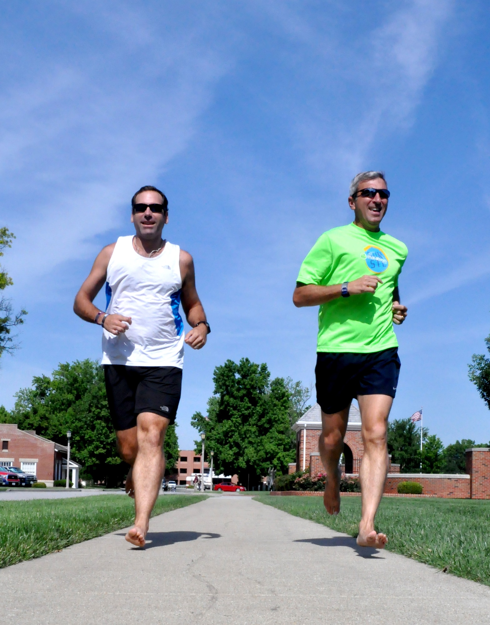 Frank Jones, 375th Air Mobility Wing communications support coordinator, right, and his running partner, William Nichols, run barefoot June 18 on base.  Running barefoot has brought many different health benefits, including less back pain, fewer aches and pains, and fewer running injuries. (U.S. Air Force photo/Staff Sgt. Maria Bowman)