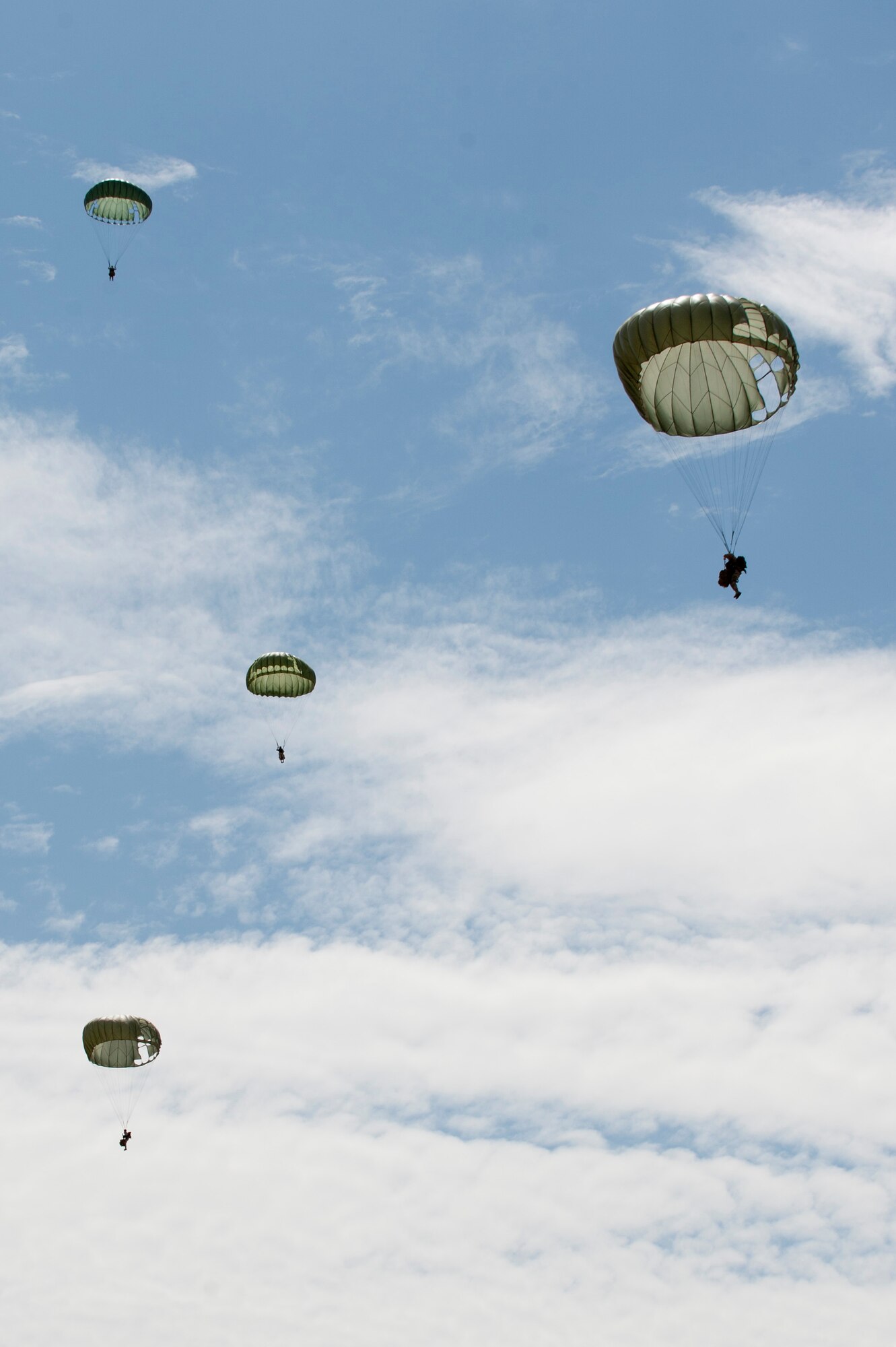 Airmen from 820th RED HORSE Airborne Flight guide themselves back to earth after a static jump July 12, 2013, at Nellis Air Force Base, Nev. The Airmen jumped out of a C-130 Hercules assigned to the 152nd Airlift Wing from the Nevada Air National Guard out of Reno, Nev., around 1,250 feet above the ground as part of a training mission. (U.S. Air Force photo by Caitlin Kenney)