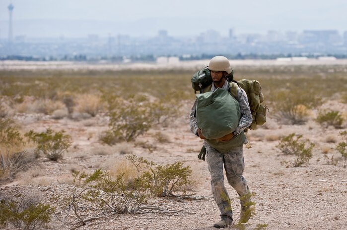 U.S. Air Force Staff Sgt. Odell Glasper, 820th RED HORSE Airborne Flight pavement and construction equipment journeyman, runs to a rally point during a training mission July 12, 2013, at Nellis Air Force Base, Nev. Airmen from the 820th RED HORSE  meet at a central location for accountability after each jump. (U.S. Air Force photo by Senior Airman Matthew Lancaster)