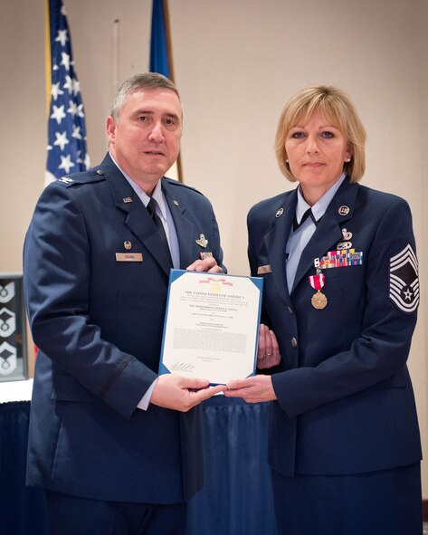 Col. Darrell Young, 934th Airlift Wing commander, presents Chief Master Sgt. Julie Carie, 934th Financial Management, with her Meritorious Service Medal during her retirement ceremony July 13, at the Minneapolis-St. Paul Air Reserve Station, Minn.  (U.S. Air Force photo/SrA Trevor Saylor)