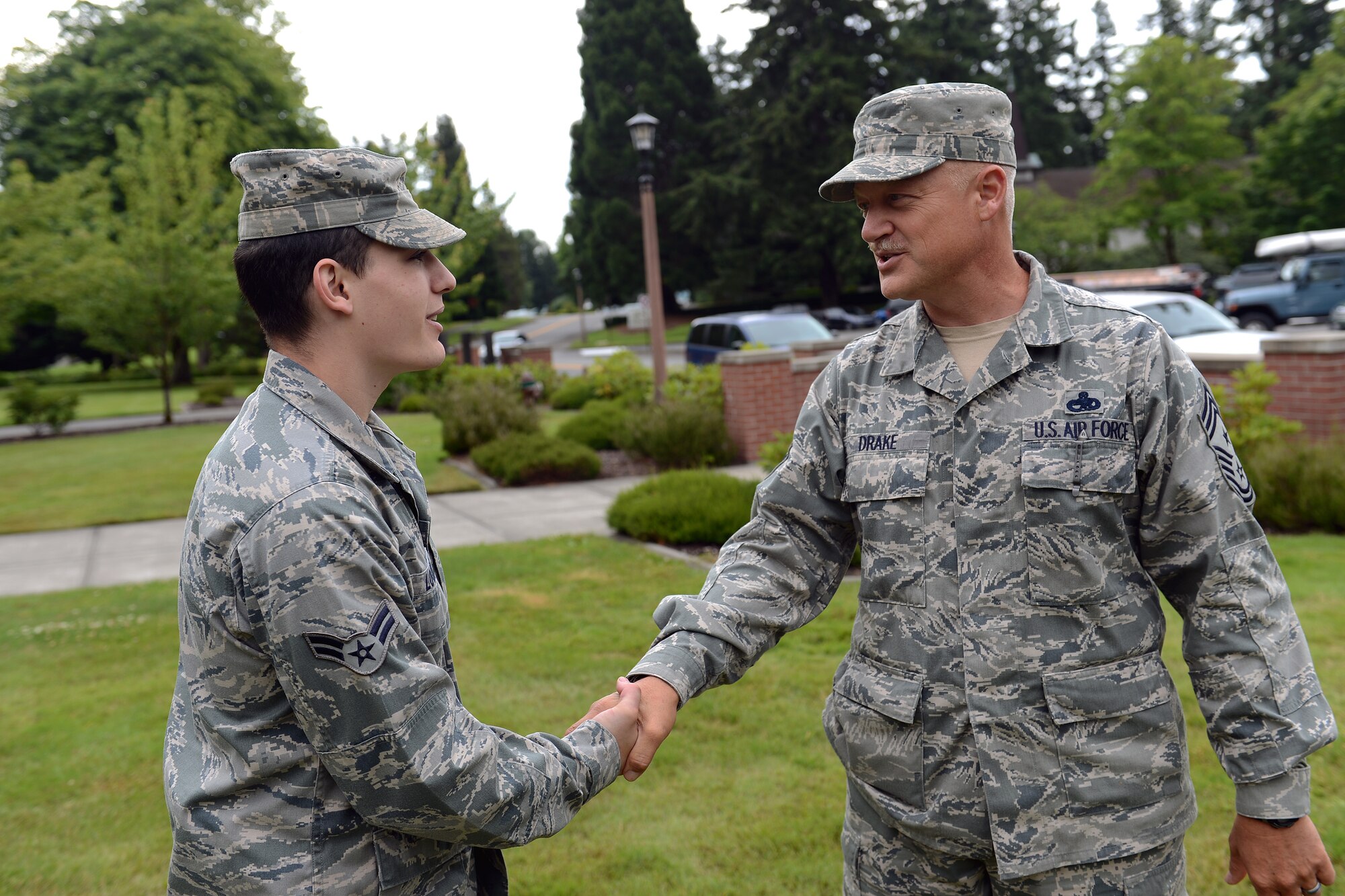 Airman 1st Class Justin Lounder, 62nd Maintenance Squadron structural maintenance technician, is coined by Chief Master Sgt. Gordan Drake, 62nd Airlift Wing command chief, July 12, 2013, for his restoration of the model C-17 Globemaster III Aircraft, on display outside the 62nd AW headquarters building, at Joint Base Lewis-McChord, Wash. After volunteering to undertake the project, Lounder dedicated more than 50 hours to restore the replica. (U.S. Air Force photo/Airman 1st Class Jacob Jimenez)