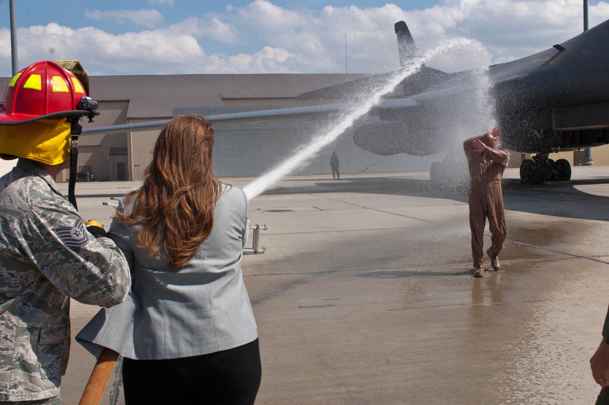 Tania Schepper, wife of Lt. Col. Timothy Schepper, 28th Operations Group senior evaluator, hoses down her husband after his return flight from Southwest Asia at Ellsworth Air Force Base, S.D., July 15, 2013. Schepper is the first B-1 bomber aviator in history to achieve 5,000 flying hours. The pilot with the next highest amount of hours at Ellsworth has flown 3,270 hours. (U.S. Air Force photo by Airman 1st Class Zachary Hada/Released)