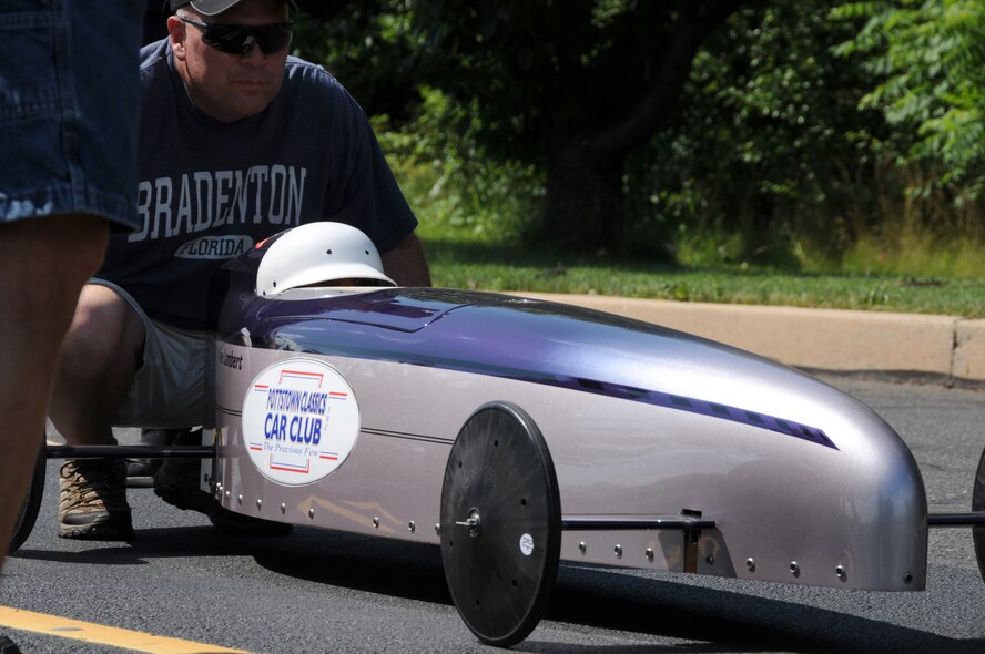 Chief Master Sgt. Paul Frisco, Jr., anti-terrorism officer for the 111th Fighter Wing, Horsham Air Guard Station, Horsham Pa., provides last minute guidance to soap box derby competitor, Anne Lambert on June 14, 2013 in Pottstown, Pa. Frisco, a year-long volunteer and car builder for over 17 years was inspired by the program when his two sons Ryan and Dylan were less than 10-years old. Like his father, Dylan, now 21, continues to volunteer yearly performing track repairs, vehicle inspections and on-site maintenance. Hundreds of cheering spectators lined the streets in the afternoon the following day for the finals, as only thousands of a second race difference defined winners and losers.