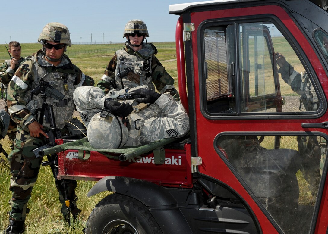 Airmen from the 28th Security Forces Squadron transport an Airman with simulated injuries during the Phase II portion of an operational readiness exercise at Ellsworth Air Force Base, S.D., July 11, 2013. The intent of OREs is to evaluate the wing’s ability to meet the wartime and contingency tasks of employing forces, sustaining forces and maintaining the ability to survive and operate in a deployed location. (U.S. Air Force photo by Airman 1st Class Anania Tekurio/Released) 