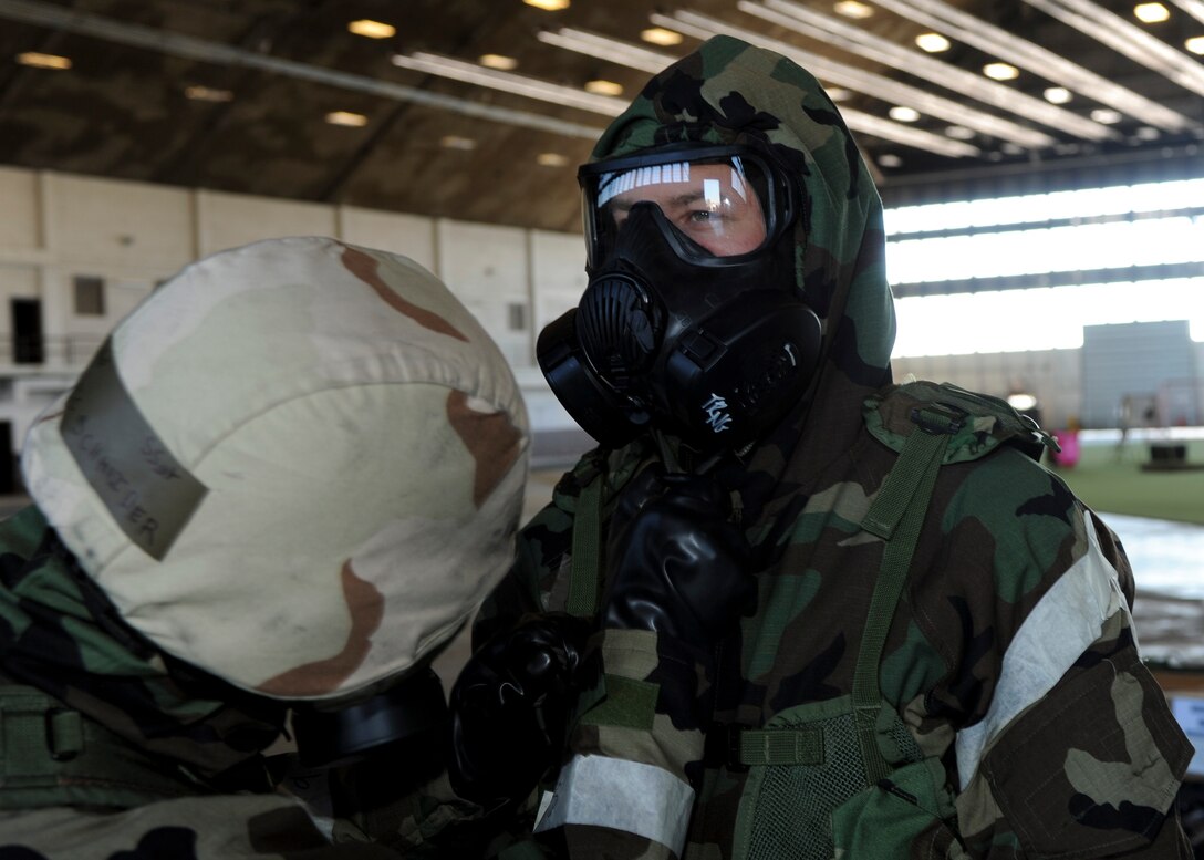 Staff Sgt. Eric Schneider checks the seal of Senior Airman Christopher McGillis’ gas mask during the Phase II portion of an operational readiness exercise at Ellsworth Air Force Base, S.D., July 10, 2013. Checking the gear and equipment of fellow wingmen is essential to ensuring safety and mission readiness while in a contaminated environment. Both Airmen are aircrew flight equipment technicians from the 28th Operations Support Squadron. (U.S. Air Force photo by Airman 1st Class Anania Tekurio/Released)