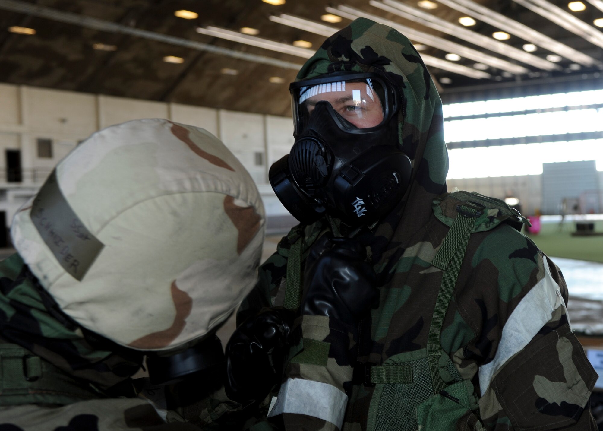 Staff Sgt. Eric Schneider checks the seal of Senior Airman Christopher McGillis’ gas mask during the Phase II portion of an operational readiness exercise at Ellsworth Air Force Base, S.D., July 10, 2013. Checking the gear and equipment of fellow wingmen is essential to ensuring safety and mission readiness while in a contaminated environment. Both Airmen are aircrew flight equipment technicians from the 28th Operations Support Squadron. (U.S. Air Force photo by Airman 1st Class Anania Tekurio/Released)