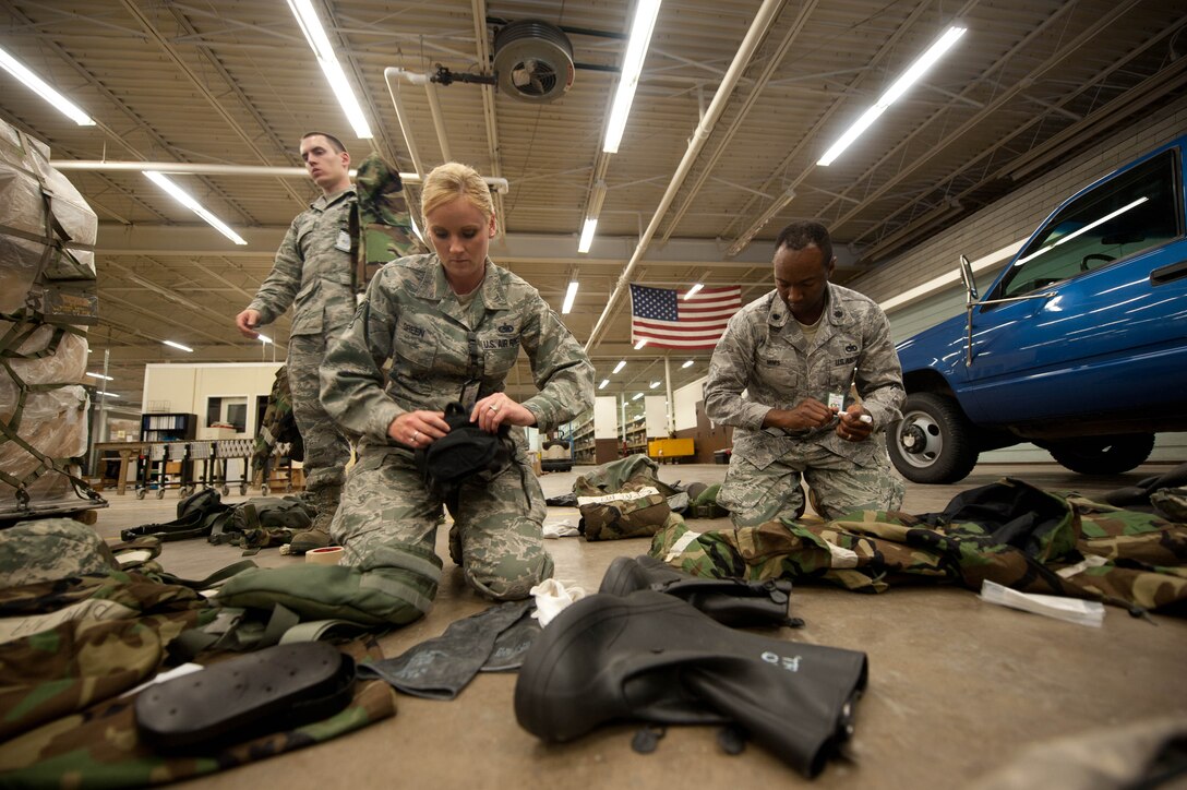 Staff Sgt. Sarah Green, 28th Logistics Readiness Squadron supply technician, inspects mission oriented protective posture gear during the Phase II portion of an operational readiness exercise at Ellsworth Air Force Base, S.D., July 10, 2013. MOPP gear consists of a chemical and biological warfare jacket and pants, protective rubber boots, rubber gloves, helmet and gas mask. (U.S. Air Force photo by Airman 1st Class Zachary Hada/Released)