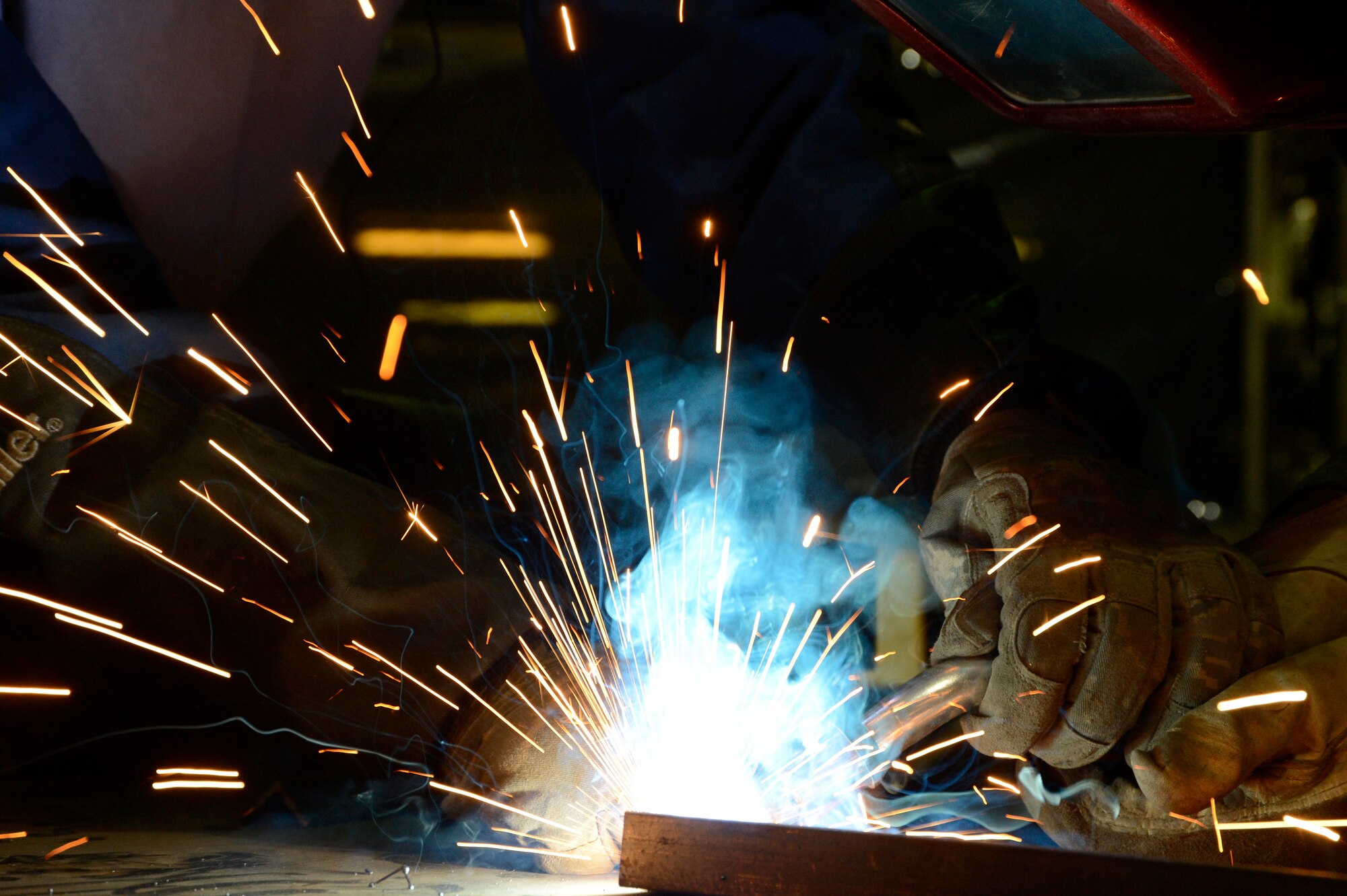 Senior Airman Kyle Zastrow, 386th Expeditionary Maintenance Squadron, performs an elbow weld while Senior Airman Isa Holland, 386th Expeditionary Maintenance Squadron, observes his work here, July 12, 2013. Zastrow is using a metal inert gas welder and being trained on welding which is not normal work for his Air Force Specialty Code. Holland is his trainer and will provide guidance on several aspects of his job during their deployment. Both are members of the combat metals shop which is utilizing two different AFSCs for a broader capability. Zastrow is deployed out of the 107th Airlift Wing, Niagara Falls N.Y. and Holland is deployed out of the 22nd Air Refueling Wing McConnell Air Force Base Kansas. (U.S. Air Force photo by Master Sgt. Christopher A. Campbell)