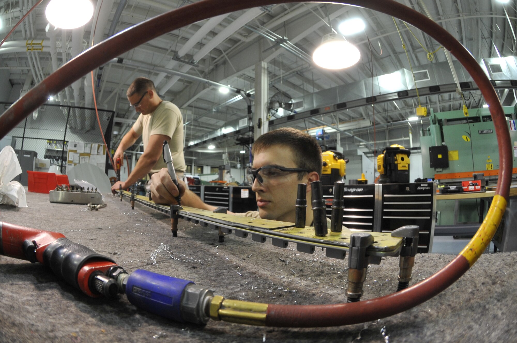 Airman 1st Class Cody Knott and Senior Airman Paul Goodrow, both Detachment 303 Aircraft Maintenance Squadron structural maintenance apprentices, replace an A-10 Thunderbolt II’s door hinge at Whiteman Air Force Base, Mo. July 1, 2013. The old hinge is removed from the  door and is used as a template to align the holes in the new hinge. If the hinge is old and worn out, the A-10’s door will not open. (U.S. Air Force photo by Airman 1st Class Keenan Berry/Released)