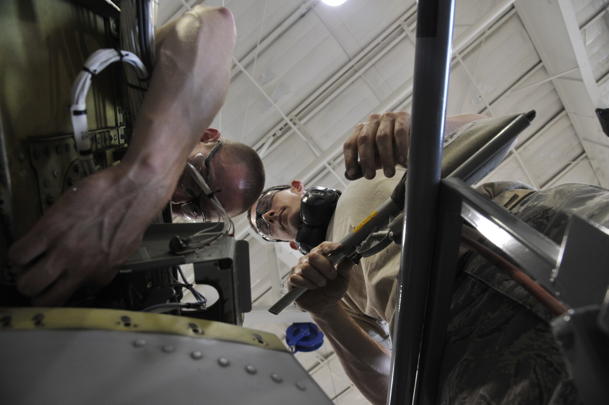 Airman 1st Class Lawerence Bowman, left, Detachment 303 Aircraft Maintenance Squadron structural maintenance apprentice, and Staff Sgt. Aaron Williams, 442nd AMXS structural maintenance apprentice, cleans foreign object debris off the A-10 Thunderbolt II’s wing at Whiteman Air Force Base, Mo. July 1, 2013. This is a requirement for each operational procedure done on the A-10 jet to prevent damage from FOD left behind. (U.S. Air Force photo by Airman 1st Class Keenan Berry/Released)