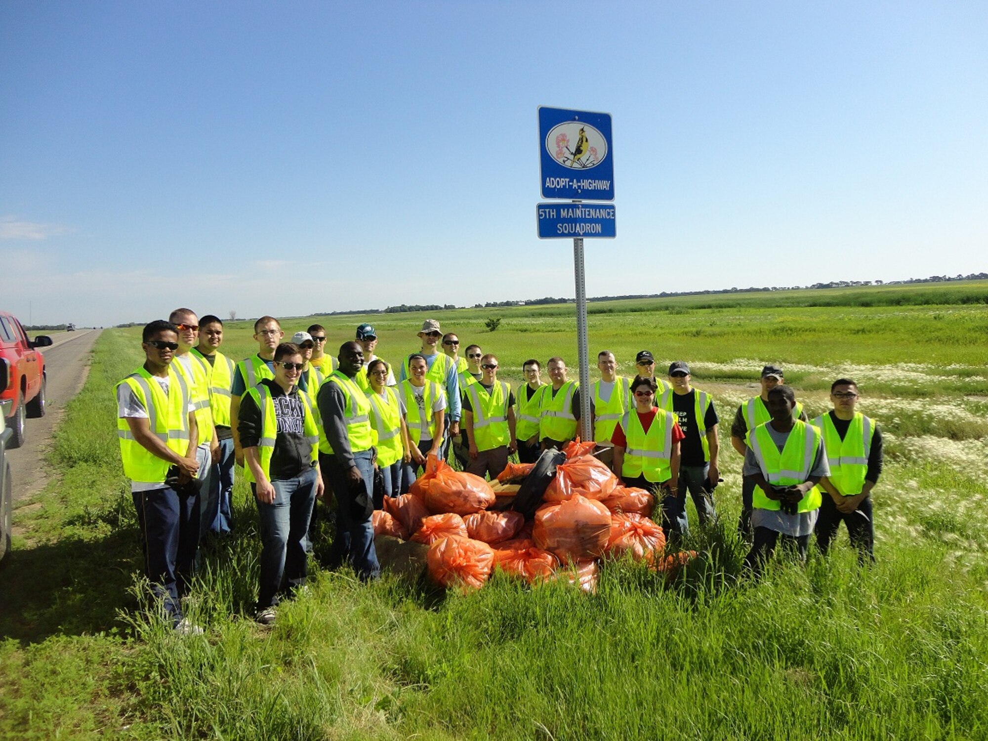 Members of the 5th Maintenance Squadron cleaned up trash, wood and vehicle debris along Highway 83 between mile markers 206 and 208, July 13, 2013. More than 20 personnel volunteered their time and energy to enhance the area as part of the Adopt-a-Highway program. The efforts made by the 5th MXS volunteers continue to build pride and solidify the bond between the base and local community. (Courtesy photo)