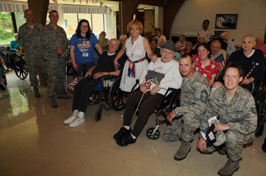 Events Director, Randie Duretz (center in white), of The Luther Woods Nursing Home and Rehabilitation Center in Horsham, Pa. extended an invitation to wing members to join clients there to celebrate their Military Appreciation month on May 21. Among the visitors to the home were Command Chief Master Sgt. Richard Mertz (left), 111th Fighter Wing Commander, Col. Howard Eissler, plans and resources superintendent for the 111th Communications Flight, Chief Master Sgt. Harley Delp and the base public affairs manager, Tech. Sgt. Elisabeth Matulewicz. The assembly of over 30 veterans, spouses and parents of veterans, shared their military experiences from days gone by and thanked the current military members for their service to the country. 