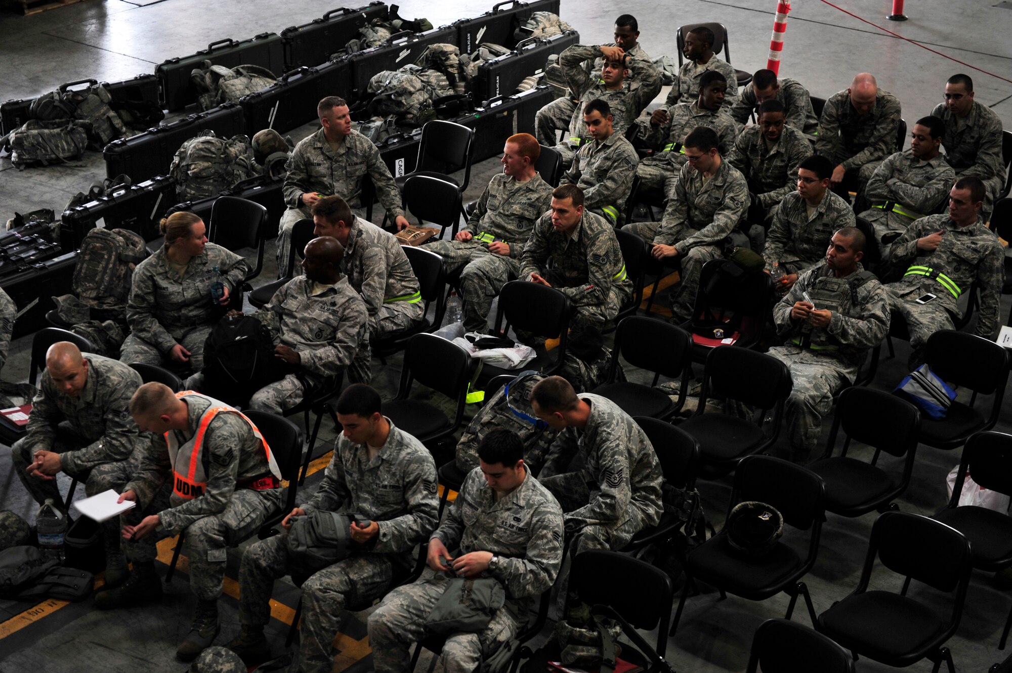 Airmen from the 374th Security Forces Squadron wait to receive an exercise pre-deployment briefing at Yokota Air Base, Japan, July 16, 2013. The briefing informed the Airmen of the general information about their simulated deployment location including local terrain and possible problems to look out for. (U.S. Air Force photo by Senior Airman Cody H. Ramirez)