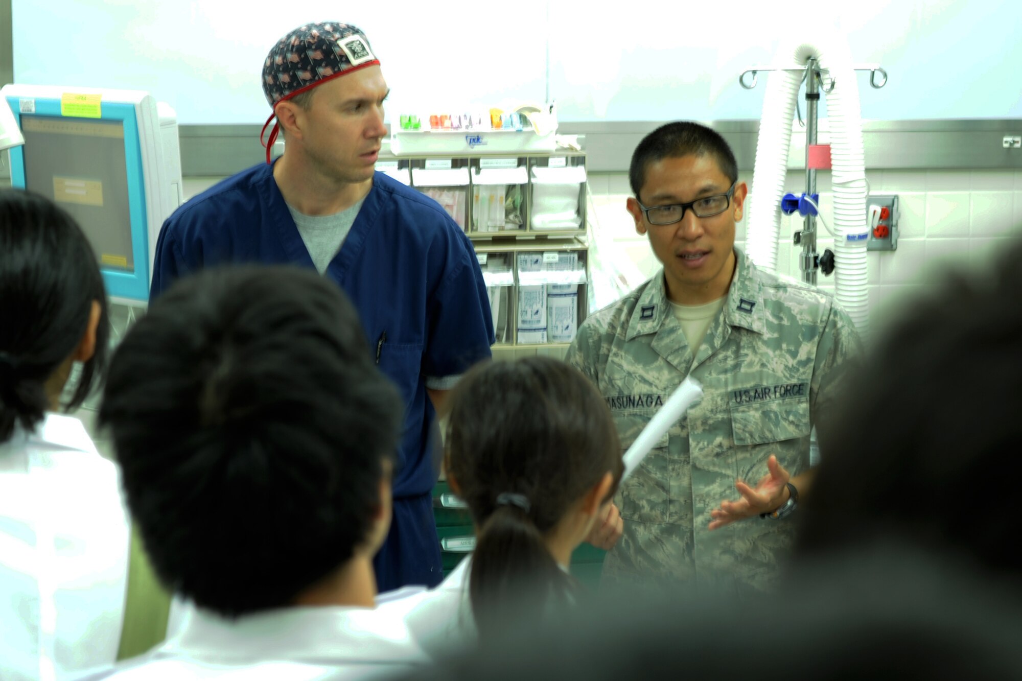 YOKOTA AIR BASE, Japan -- Right, Capt. Evan Masunaga, 374th Dental Squadron, translates information briefed by Maj. Jason Bolt, 374th Surgical Operations Squadron, July 11, 2013, at Yokota Air Base, Japan. Students from the National Defense Medical College visited the 374th Medical Group to learn about hospital operations at Yokota. (U.S. Air Force photo by Senior Airman Desiree Economides)