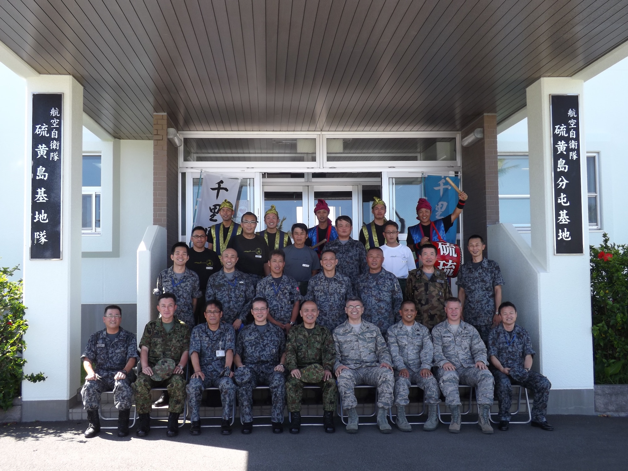 Chief Master Sgts. Manuel Roblesreynoso, 374th Airlift Wing command chief; Rick Ramos, 515th Air Mobility Operations Group command chief and Jason Williams, 374th Operations Support Squadron air traffic control superintendent, sit with senior Japanese enlisted leadership outside of the headquarters building at Iwoto, Japan, June 20, 2013. Iwoto was formerly named Iwo Jima, but was renamed in 2007. (Courtesy photo)