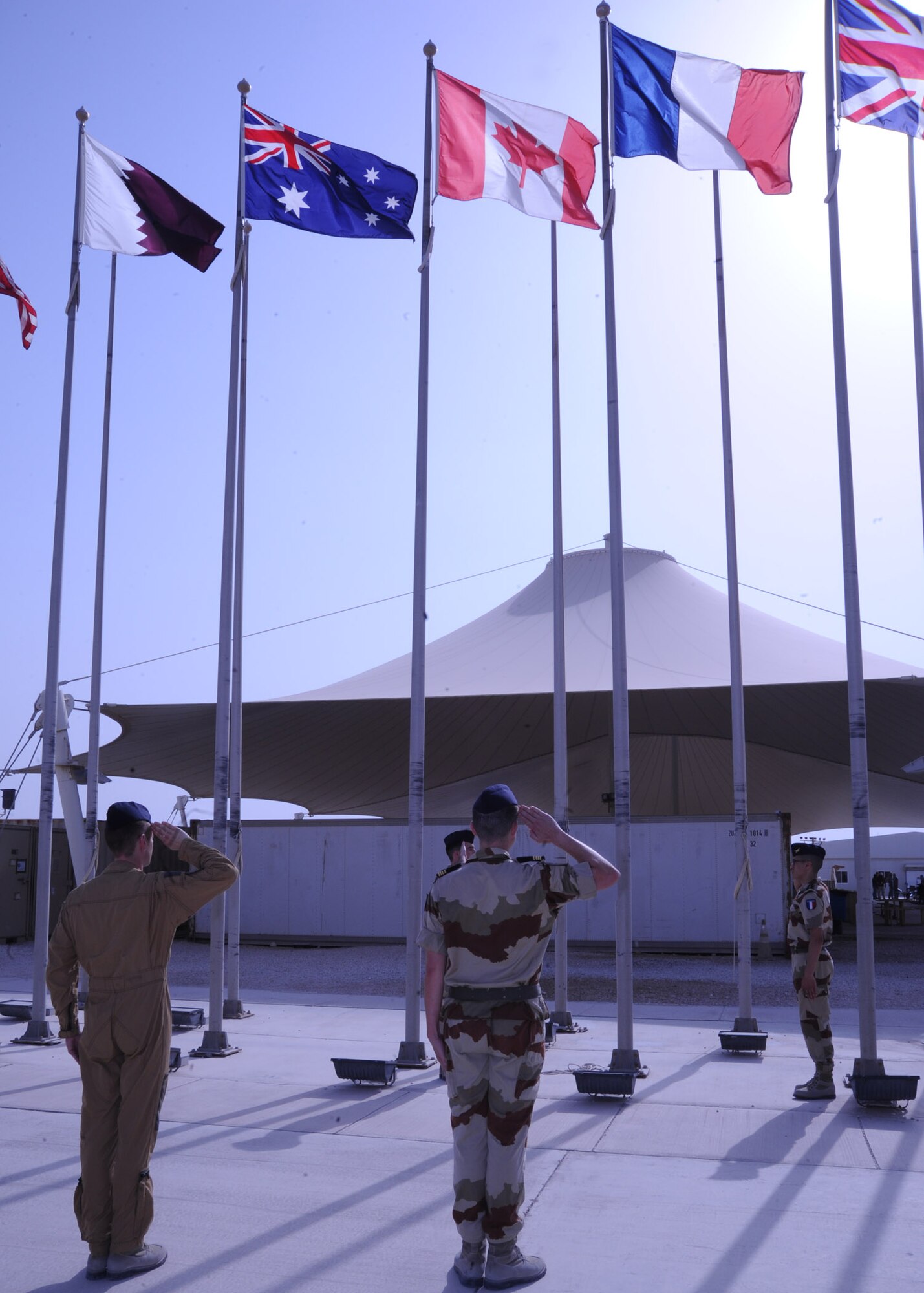 French Air Force Majs. Paul Boinet-Dupuet and Thibault Chazelle salute the French flag during a Bastille Day ceremony at the 379th Air Expeditionary Wing in Southwest Asia, July 14, 2013. Bastille Day is holiday marking the anniversary of the fall of Bastille in Paris in 1789. Boinet-Dopuet and Chazelle are assigned to the Combined Air and Space Operations Center French Detachment. (U.S. Air Force photo/Senior Airman Bahja J. Jones) 