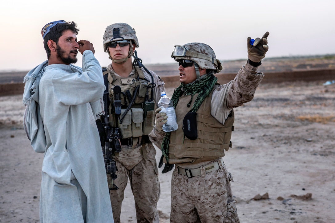 U.S. Marine Corps Sgt. Robert Medel, center, and an Afghan linguist, right, talk with an Afghan villager while patrolling in Helmand province, Afghanistan, July 5, 2013. Medel is assigned to Echo Company, 2nd Battalion, 8th Marine Regiment.