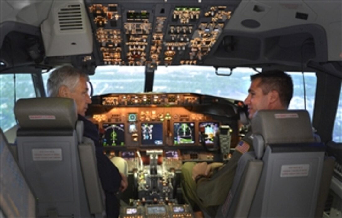 Secretary of Defense Chuck Hagel, left, sits in the cockpit of a P-8 Poseidon aircraft flight simulator as he visits the Patrol Squadron 30 training center at Naval Air Station Jacksonville, Fla., on July 16, 2013.  Hagel is visiting the station to conduct town hall meetings and receive briefings from Navy and civilian leaders on the impact of furloughs and sequestration on their lives and operations.  