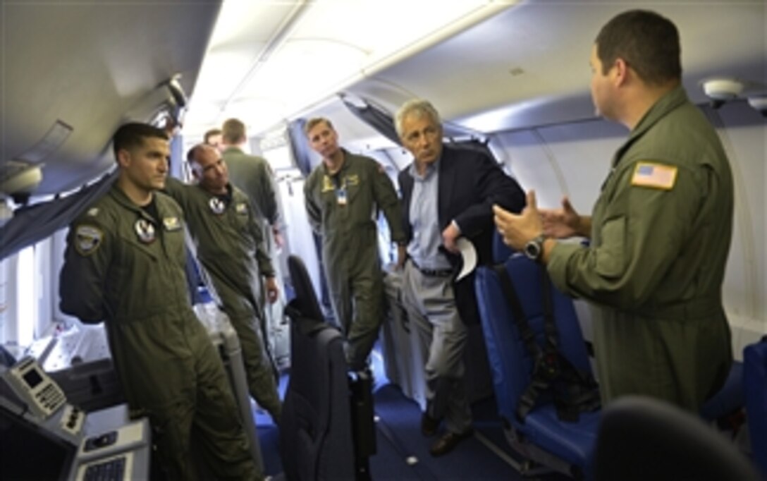 The flight crew of a U.S. Navy P-8A Poseidon briefs Secretary of Defense Chuck Hagel, second from right, as he visits the Patrol Squadron 30 training center at Naval Air Station Jacksonville, Fla., on July 16, 2013.  Hagel is visiting the station to conduct town hall meetings and receive briefings from Navy and civilian leaders on the impact of furloughs and sequestration on their lives and operations.  