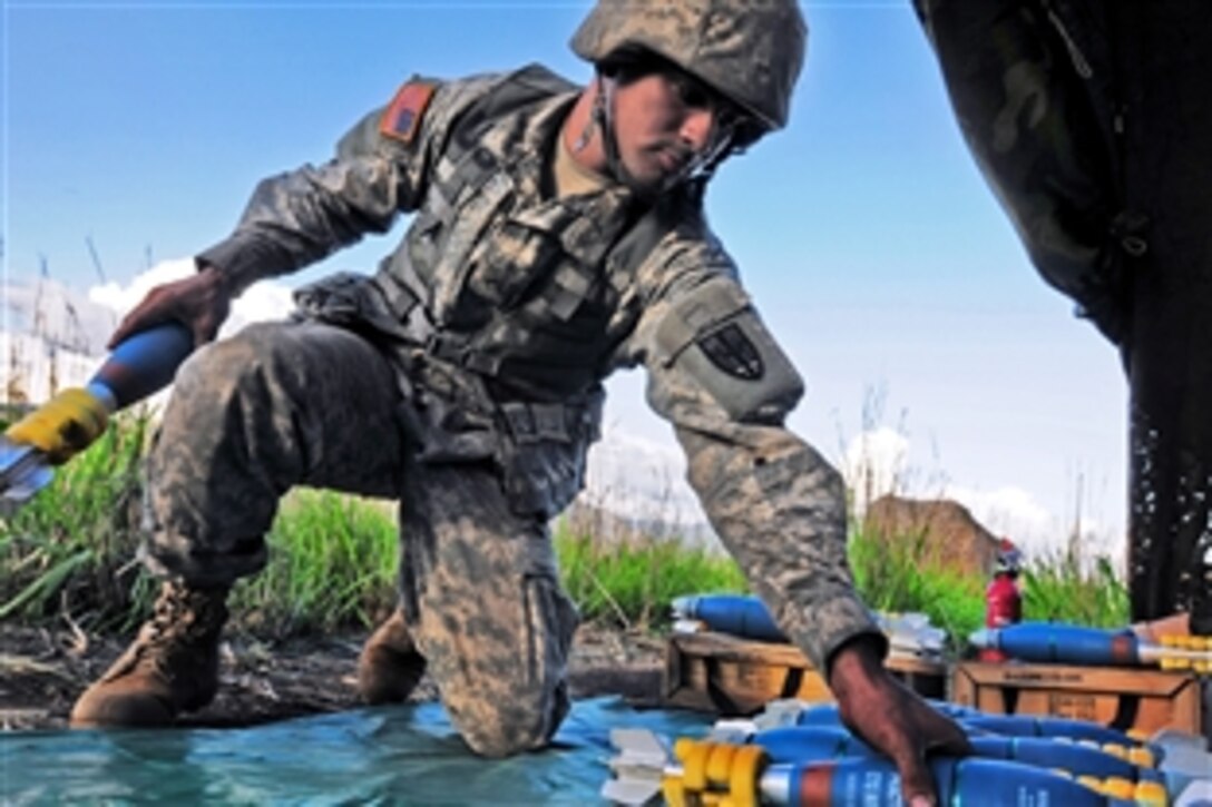 Army Pfc. Victor Perez prepares 81mm rounds to be used on his 81mm mortar before a training mission on Camp Santiago Joint Maneuver Training Center in Salinas, Puerto Rico, July 15, 2013. Perez is assigned to the Puerto Rico National Guard's Headquarters Company, 1st Battalion, 296th Infantry Regiment, 101st Troop Command.