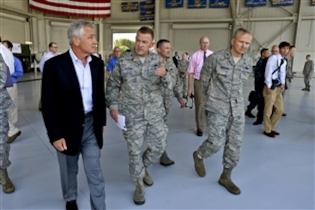 Air Force Col. Richard D. McComb, commander of Joint Base Charleston, escorts Defense Secretary Chuck Hagel on a tour of a C-17 hangar in Charleston, S.C. July 17, 2013. 