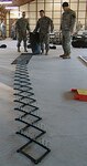 Members of the 56th Stryker Brigade Combat Team, 28th Infantry Division, practice laying out spike strips during non-lethal capability set training at Fort Dix, N.J.