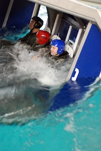 Soldiers enter the water while strapped in to the seats of the Modular Egress Training System. Once under water, the Soldiers unstrapped their seatbelts and safely swam to the surface.