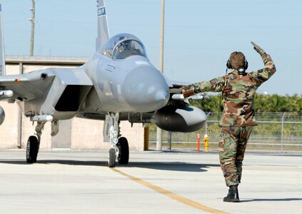 Tech. Sgt. Aaron Hartley of the Florida Air National Guard's Det. 1, 125th Fighter Wing, guides an F-15 Eagle Fighter Wing on the flightline at Homestead Air Reserve Base, Fla., Feb. 5, 2009.