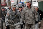 Air Force Gen. Craig R. McKinley, chief of the National Guard Bureau, right, and Army Capt. Shannon Dean Holiday, commander for Multi-National Task Force East, Thunder Bravo battery, walk the streets of downtown Pristina, Kosovo, during a presence patrol with the Missouri Army National Guard. The Guard Soldiers patrol one of the more populated areas of the American NATO peacekeeping missions in Kosovo.