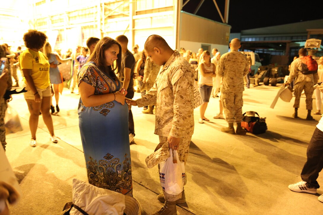 Lance Cpl. Jonathan Zuniga, an aircraft intermediate level structures mechanic with Marine Aviation Logistics Squadron 14, greets his wife and unborn child after returning from a six-month deployment to Marine Corps Air Station Iwakuni, Japan, July 15.
